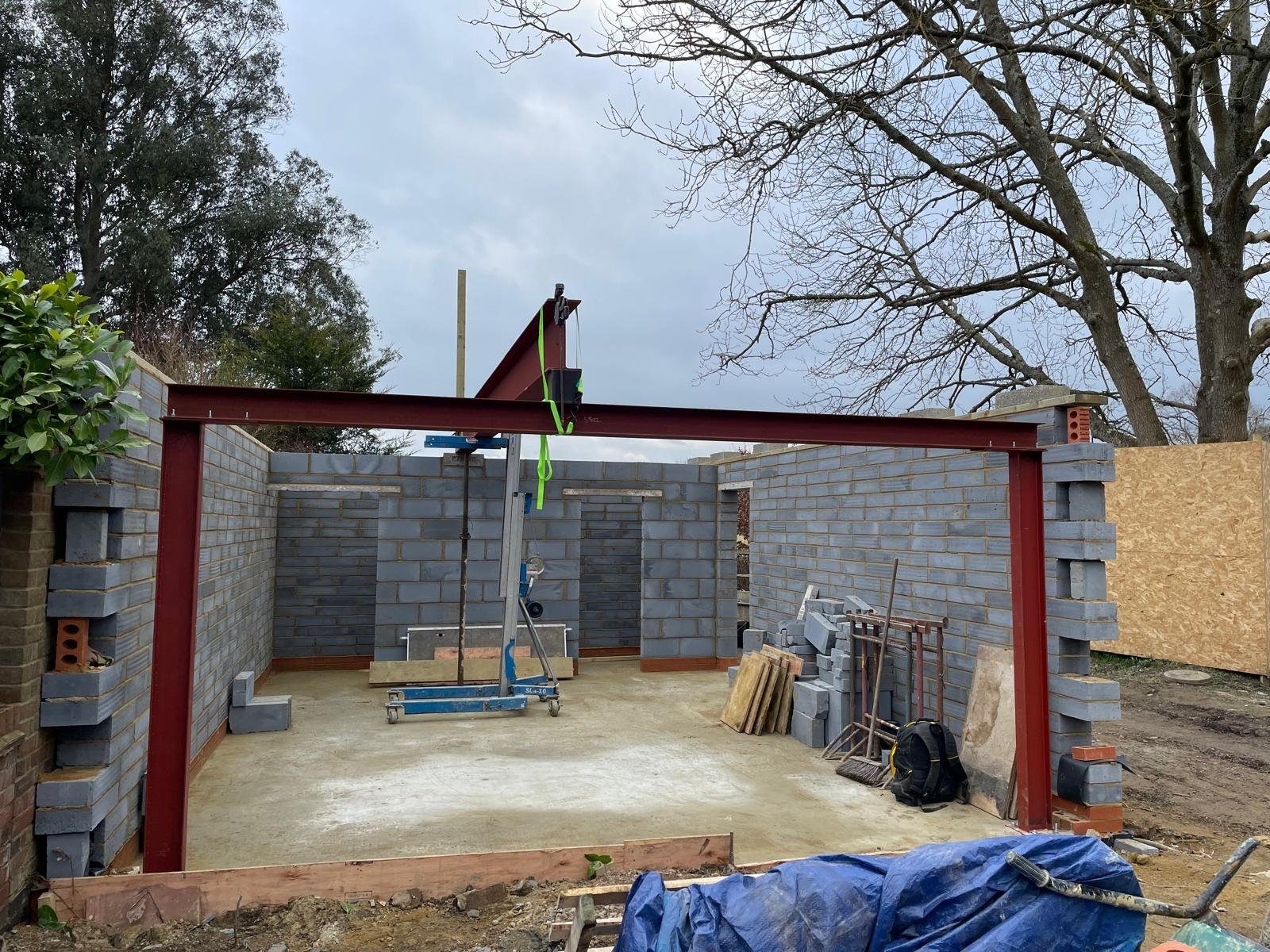 A steel goalpost frame and blockwork walls going up on an I.C Developments extension in Surrey